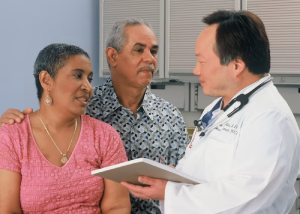 Two doctors talking together, one holding a tablet
